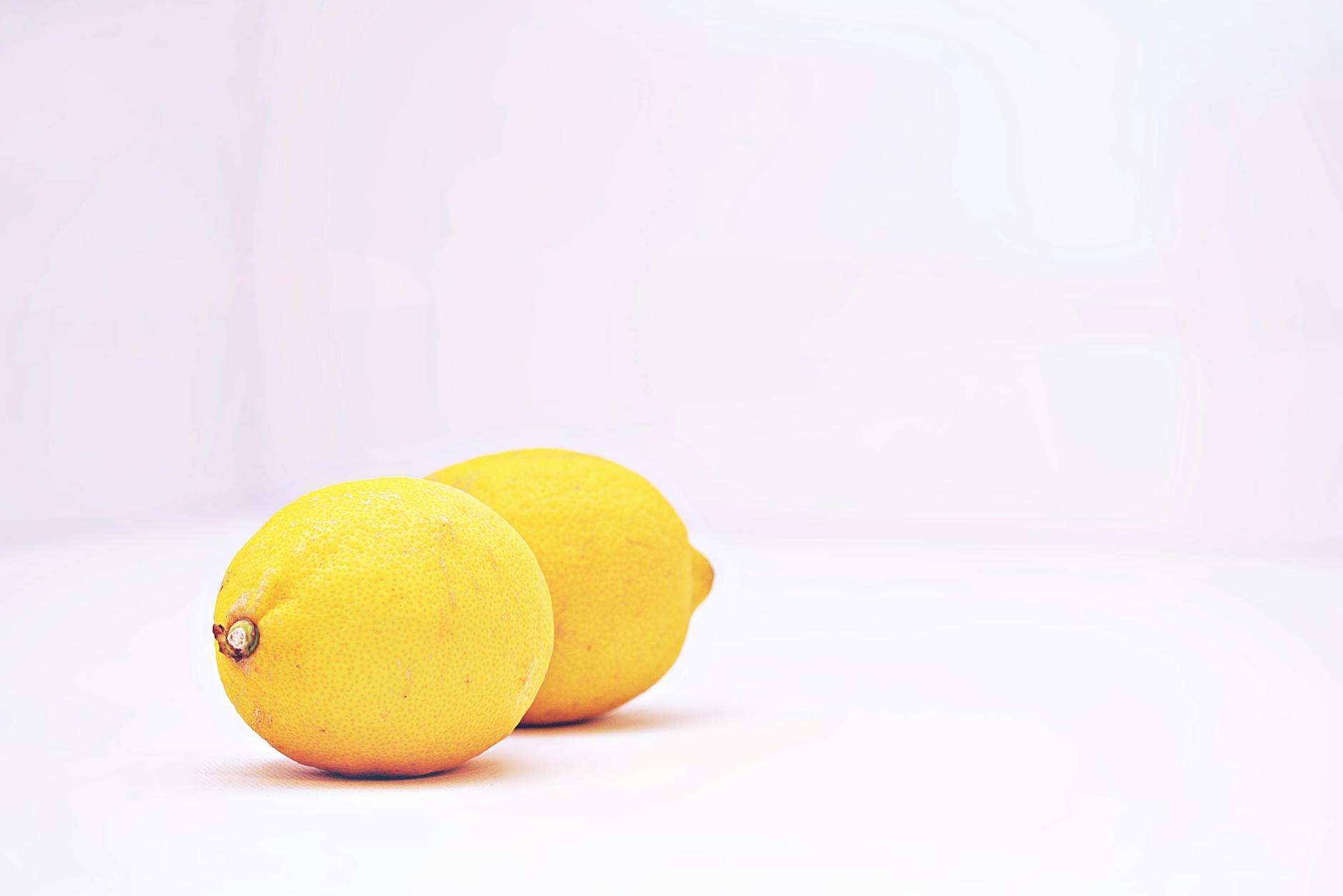 Hand holding an orange vibrator against a minimalist purple backdrop, showcasing modern sensuality and intimate empowerment