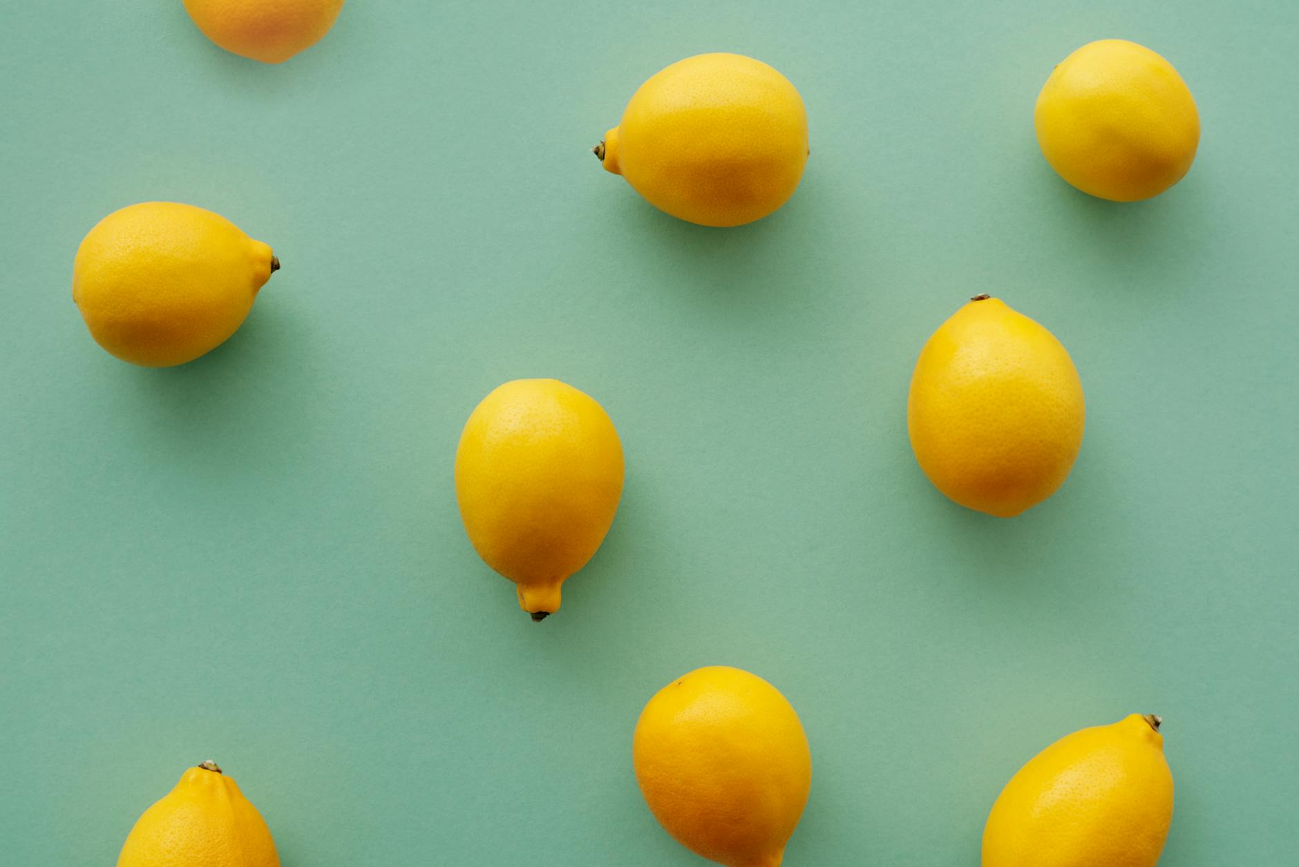 Bright yellow lemons on a pastel green background, symbolizing fresh beginnings and restored sensation