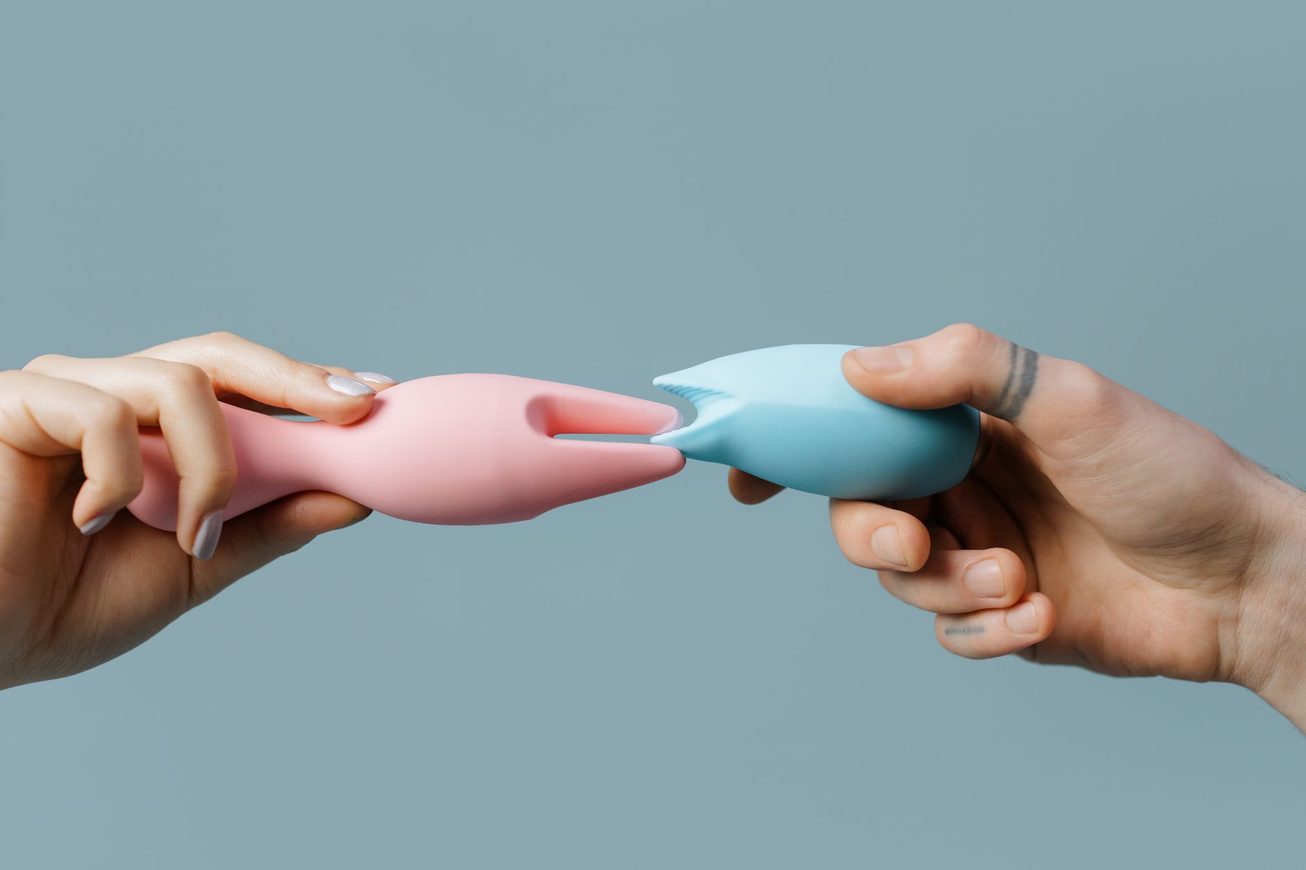 A hand holding a bright lemon on a soft pink background, symbolizing warmth and reconnection