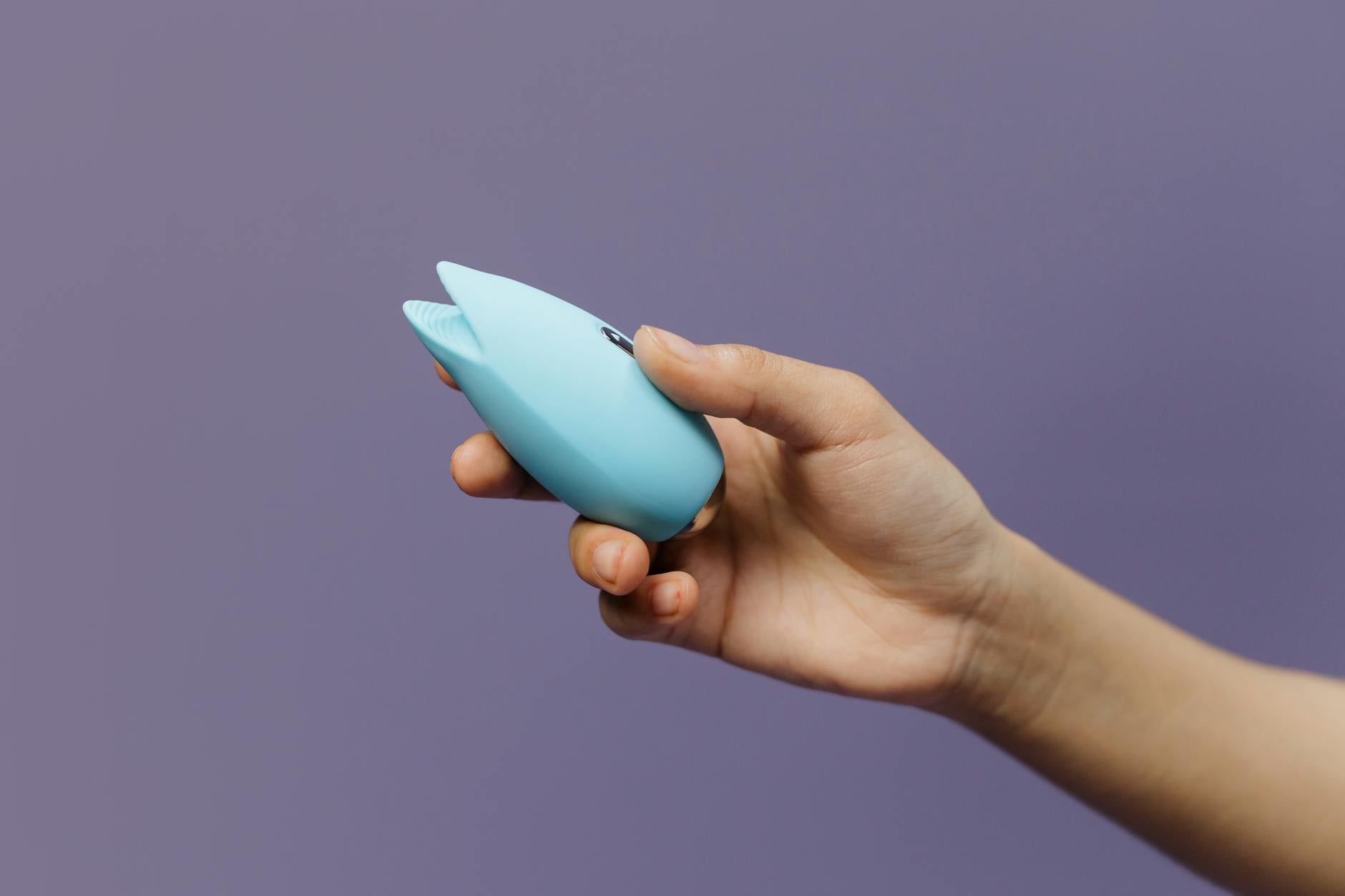 Woman holding two colorful vibrators, representing safe pleasure options for pelvic pain