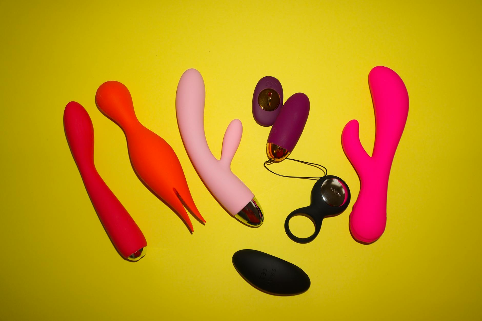 Hand holding a vibrator against a minimalist purple background, showcasing modern sensuality and control