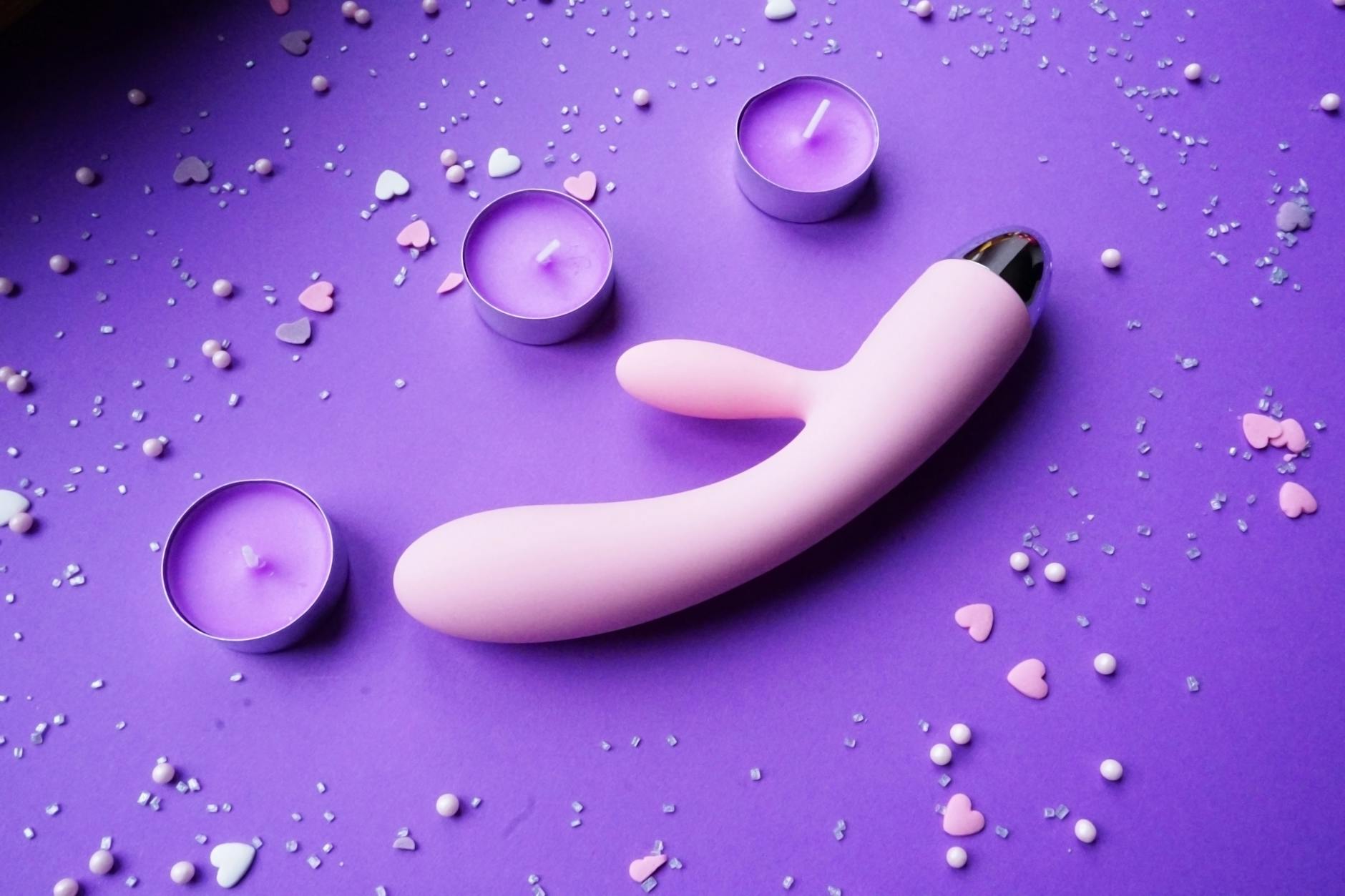 A young couple standing together indoors holding a blue vibrator, symbolizing modern intimacy and shared pleasure.