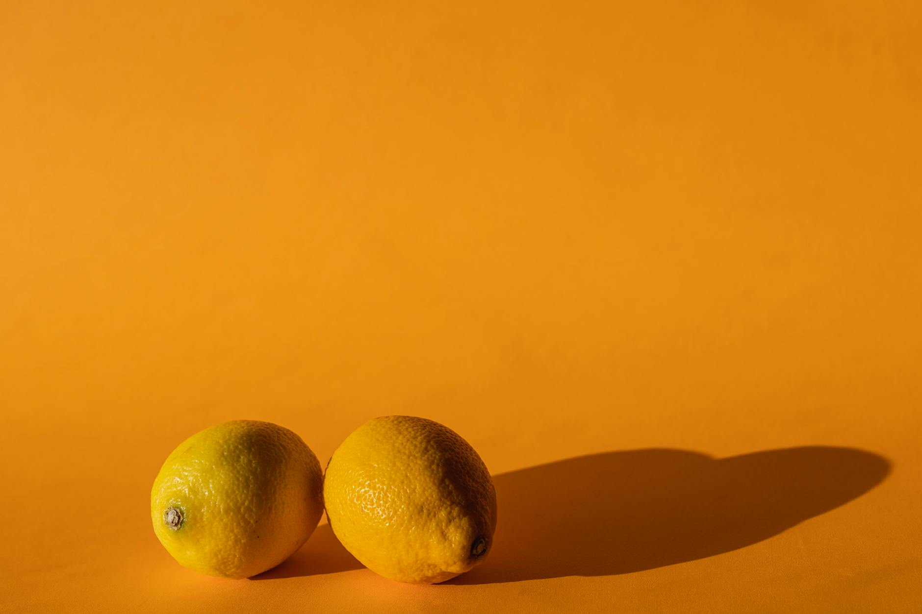 Ripe vivid lemons on bright yellow background representing the lemon vibrator